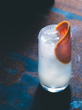 Beyaz roily kokteyl pürüzsüz bir şeffaf cam buz küpleri ile taze greyfurt paslı bir arka plan üzerinde sağ parçası ile dekore edilmiştir. Arka ışık, dikey yönlendirmesi, metin alanı