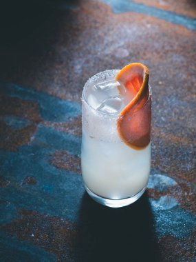 Beyaz roily kokteyl pürüzsüz bir şeffaf cam buz küpleri ile taze greyfurt paslı bir arka plan üzerinde sağ parçası ile dekore edilmiştir. Arka ışık, dikey yönlendirmesi, metin alanı