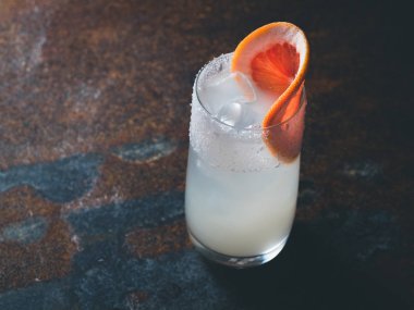 Beyaz roily kokteyl pürüzsüz bir şeffaf cam buz küpleri ile taze greyfurt paslı bir arka plan üzerinde sağ parçası ile dekore edilmiştir. Arka ışık, yatay yönlendirme, metin alanı