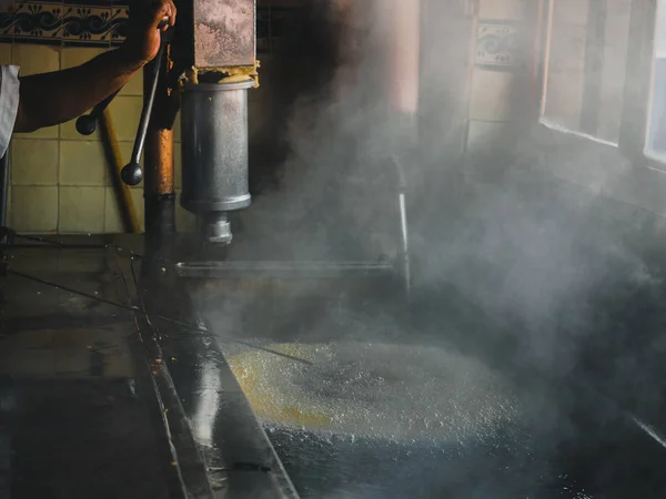 Anel enorme de Churros fervendo em óleo, vapor chegando. Dentro da velha churreria. Cozinha espanhola (mexicana) — Fotografia de Stock