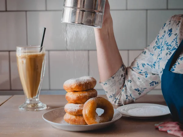 Pishki - Rus çörek. Kız toz pudra şekeri çörek üzerinde geleneksel kantinde bir arka plan üzerinde uzun bir şeffaf bardak kakao içmeye kız. Yatay fotoğraf