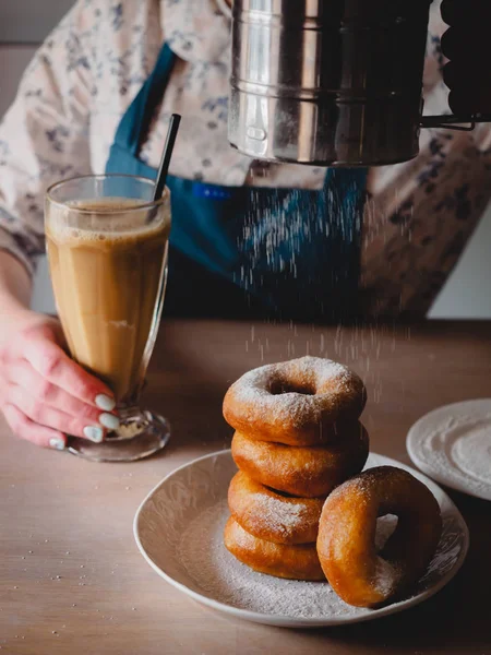 Pishki - Rus çörek. Kız toz pudra şekeri çörek üzerinde geleneksel kantinde bir arka plan üzerinde uzun bir şeffaf bardak kakao içmeye kız. Dikey fotoğraf