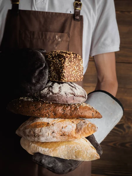 Taze pişmiş ekmekler bir genç Fırıncılar ellerinde çeşitli