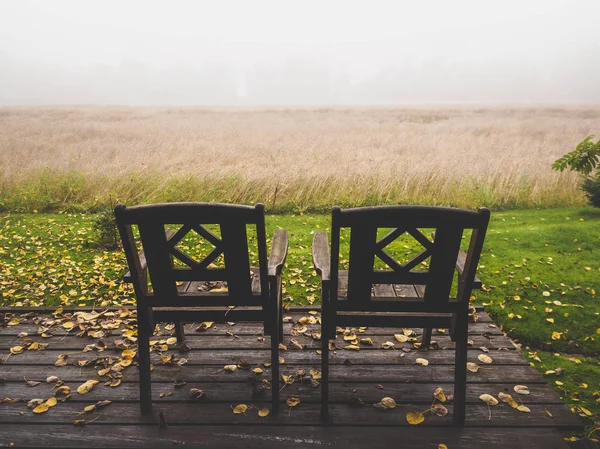 Puste drewniane krzesła w pobliżu pole rolne — Zdjęcie stockowe
