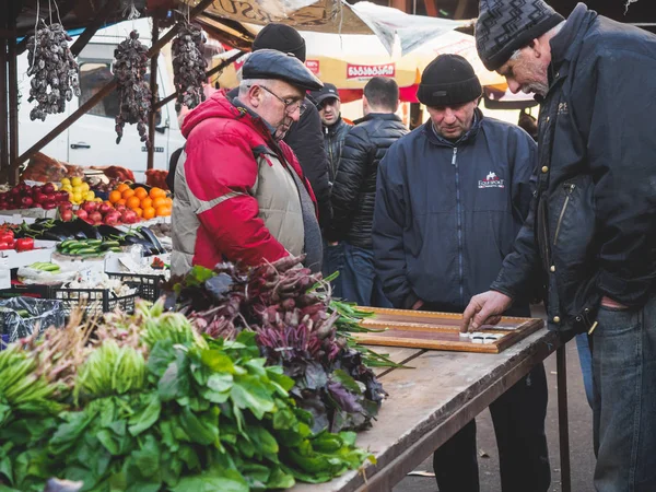 Tiflis, Gürcistan. dezerter çarşı, Kent Gıda pazarı. 27 Aralık 2017. Yaşlı adam sokakta oynuyor