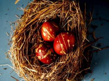 Güzel kırmızı ve altın yumurta saman üzerinde. Üç yumurta saman üzerinde. Yatay fotoğraf, üstten görünüm