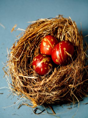 Güzel kırmızı ve altın yumurta saman üzerinde. Üç yumurta saman üzerinde. dikey fotoğraf