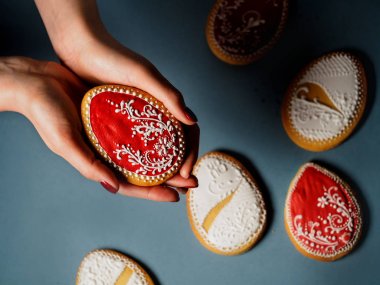Paskalya yumurta şekilli kurabiyeler. Bir çerez holding eller. Yatay fotoğraf, üstten görünüm