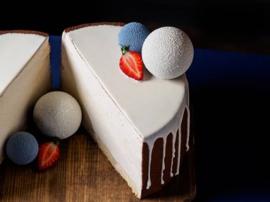 Beyaz çikolata kadife ile kaplı ve çikolata küre ile dekore kek yakın çekim Mus şaşırtıcı. Kesilmiş yarım, yatay fotoğraf, koyu arka plan