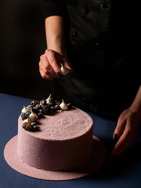 el Close-Up lezzetli pembe mousse kek koyu arka plan üzerinde çikolata şekerleme ile dekore edilmiştir.