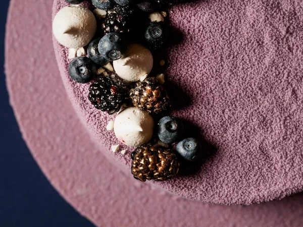 lezzetli mousse kek Close-Up pembe sır ile kaplı ve koyu arka plan üzerinde çikolata şekerleme ile dekore edilmiş