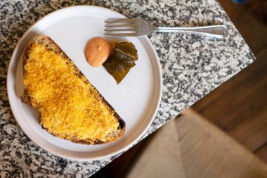 Kahvaltı masası: yukarıdaki mermer masada yumurtalı sandviç, meyve suyu ve salata.