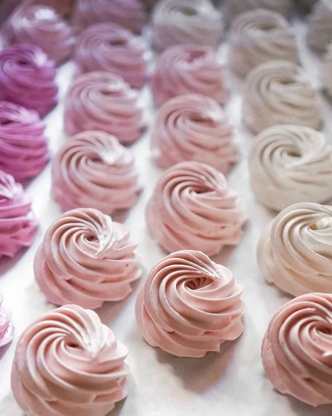 Büyük grup pastalarını pastel renkte krem şantiyle beyazdan pembeye fırınlama kağıdında pembeye kapat