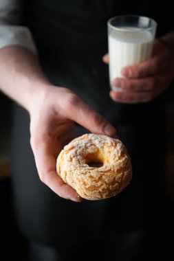 Süt dolu erkek eli ile fırında çörek.