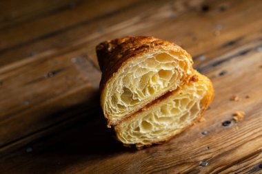 Mükemmel kruvasan kesimi. Tahta bir masada sade kruvasan kesiği.