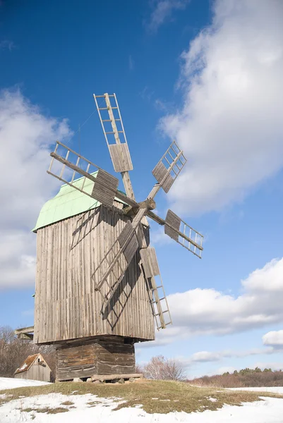 Moinho de vento contra um céu azul com nuvens no inverno — Fotografia de Stock