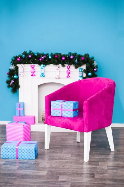 Regalos de Navidad y una silla frente a la chimenea — Foto de Stock