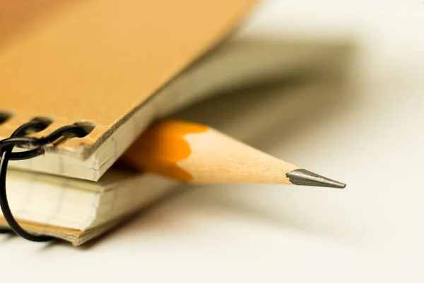 Pencil on the pages of an closed notebook for records — Stock Photo, Image