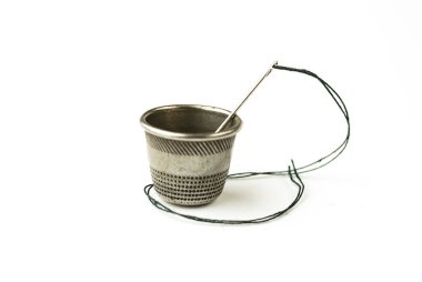 Metal yüksük ve iğne ile beyaz iş parçacığında