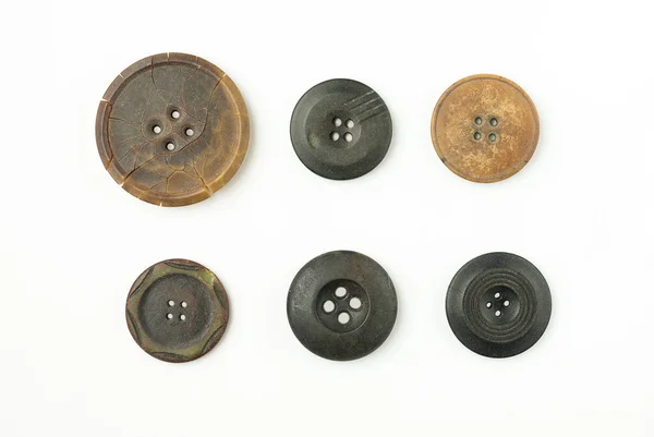 Много старых круглых кнопок с трещинами на белом — стоковое фото