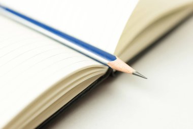 Açılan not defteri ve kalem üzerinde beyaz üzerinde