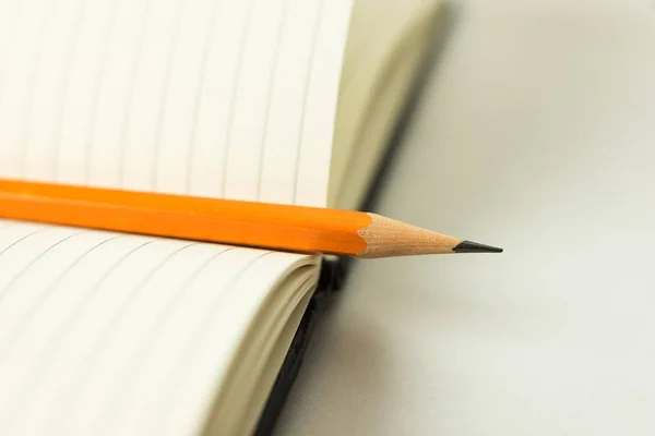 Caderno aberto e lápis sobre branco — Fotografia de Stock