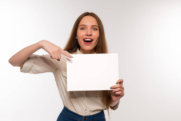 The girl is holding a sheet of blank paper in front of her