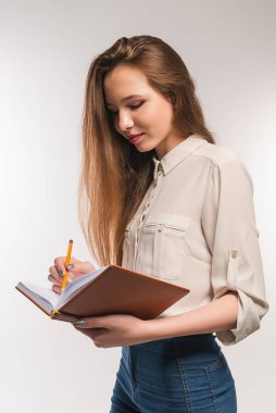 Young girl with pencil and book in hands clipart