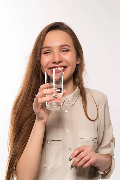 Ung flicka dricker rent vatten från ett glas Stockbild