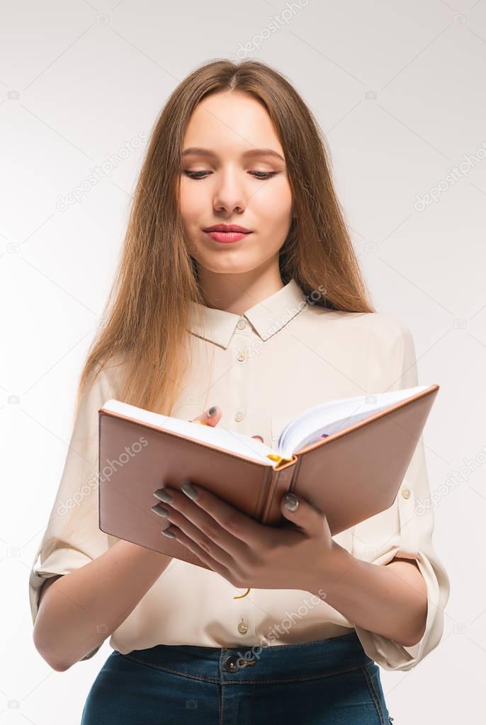 Young girl with pencil and book in hands