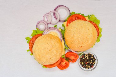 Peynir, et, domates ve soğan ve otlar ile hamburger. Ahşap arka plan üzerinde. Üstten Görünüm. Boş alan.