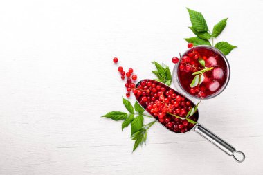 Ahşap arka plan üzerinde buz ile taze kırmızı kuş üzümü kokteyl. Üstten Görünüm. Boş alan.