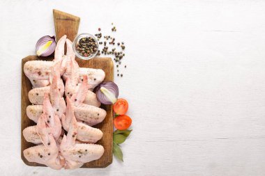 Baharat ile çiğ tavuk kanatları. Ahşap yüzeyde. Üstten Görünüm.