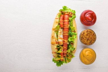 Sosisli otlar ve Baharatlar, hardal ve ketçap. Ahşap arka plan üzerinde. Üst alanı ile ilgilenen.