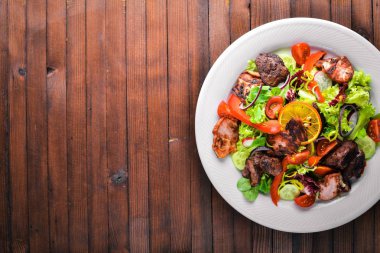 Salata taze salatalık, domates ve yeşillik bir plaka ahşap tahta üzerinde ızgara et ile. Üstten Görünüm. Boş alan.