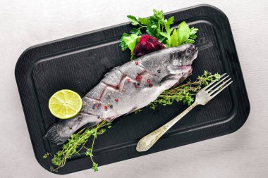 Balık alabalık aromatik otlar ve baharatlar ile. Ahşap arka plan üzerinde.