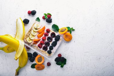 Taze meyveler ve meyve yulaf ezmesi. Sağlıklı bir diyet yemek. Öğle Yemeği boks. Ahşap bir arka plan üzerinde. Üstten Görünüm. Metin için boş alan.