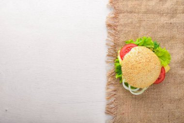 Ahşap arka plan üzerinde peynir, et ve yeşil soğan ile hamburger. Üstten Görünüm. Boş alan.