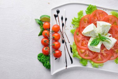 Mozzarella peyniri domates ve zeytinyağı ile. İtalyan yemeği. Ahşap bir arka plan üzerinde. Üstten Görünüm. Metin için boş alan.