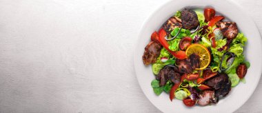 Salata taze salatalık, domates ve yeşillik bir plaka ahşap tahta üzerinde ızgara et ile. Üstten Görünüm. Boş alan.