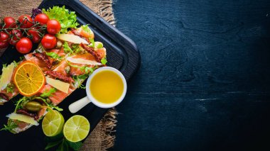 Somon Bruschetta otlar ve parmesan peyniri ekmeğin. Soğuk aperatifler. İtalyan mutfağı. Ahşap arka plan üzerinde.