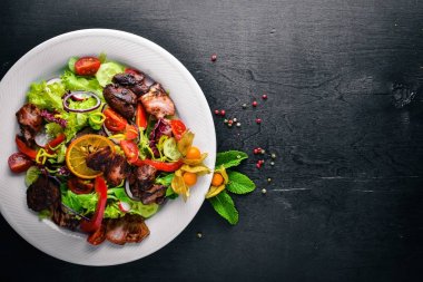 Salata taze salatalık, domates ve yeşillik bir plaka ahşap tahta üzerinde ızgara et ile. Üstten Görünüm. Boş alan.