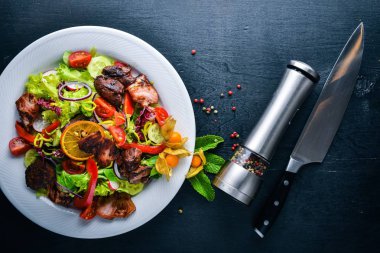 Salata taze salatalık, domates ve yeşillik bir plaka ahşap tahta üzerinde ızgara et ile. Üstten Görünüm. Boş alan.