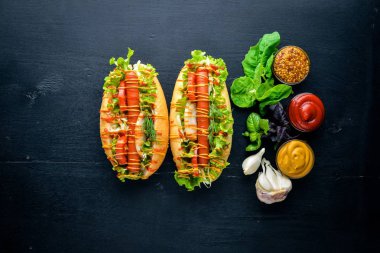 Sosis ızgara sosis, hardal ve ketçap, soğan ve Yeşiller ahşap arka plan üzerinde. Üstten Görünüm. Boş alan.