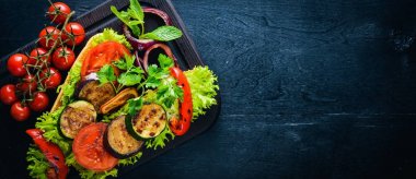 Bruschetta ızgara sebze, zeytin, otlar ve parmesan peyniri ekmeğin. Soğuk aperatifler. İtalyan mutfağı. Ahşap arka plan üzerinde.