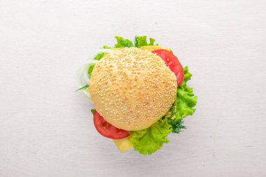 Ahşap arka plan üzerinde peynir, et ve yeşil soğan ile hamburger. Üstten Görünüm. Boş alan.