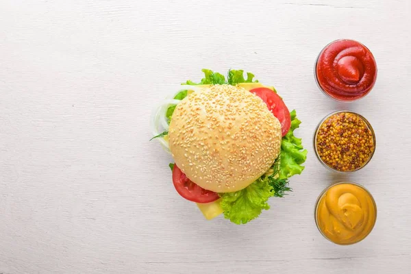 Ahşap arka plan üzerinde peynir, et ve yeşil soğan ile hamburger. Üstten Görünüm. Boş alan.