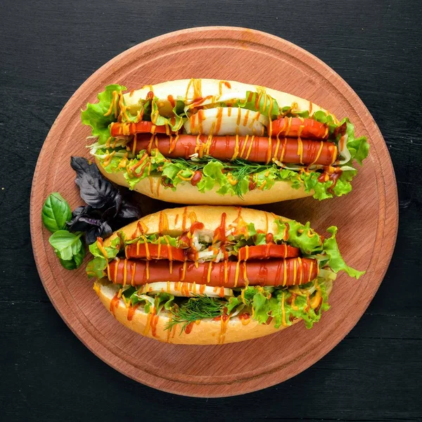 Sosis ızgara sosis, hardal ve ketçap, soğan ve Yeşiller ahşap arka plan üzerinde. Üstten Görünüm. Boş alan.