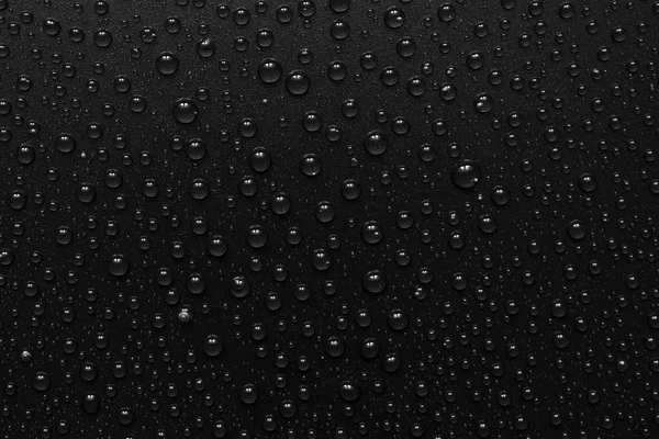 Vatten droppar på svart bakgrund. Makro. — Stockfoto
