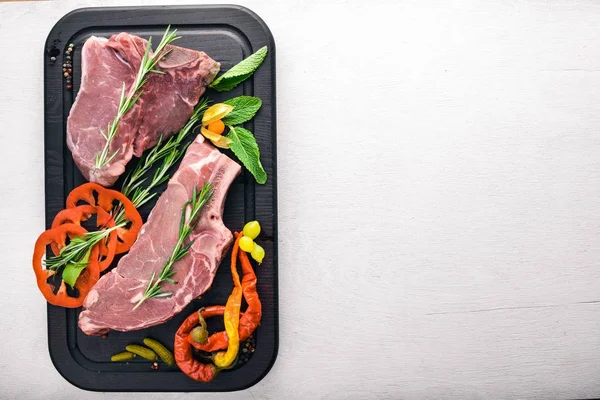 Biftek çiğ et ve baharat ahşap tahta üzerinde. Üstten Görünüm. Boş alan.